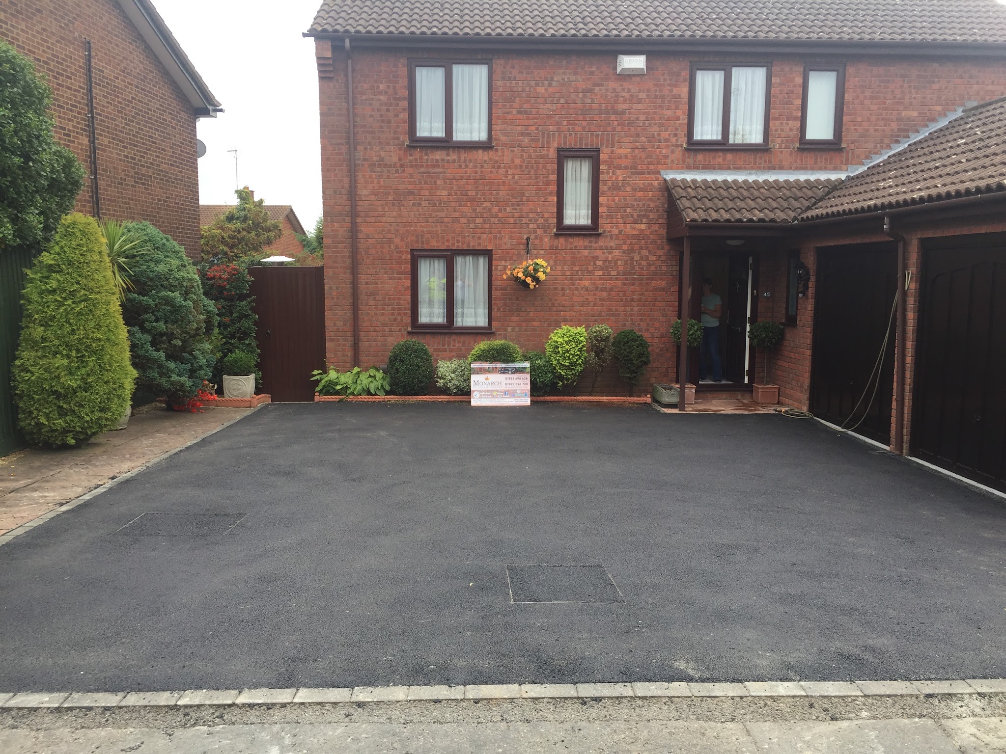 Newly laid tarmac driveway in front of a double garage