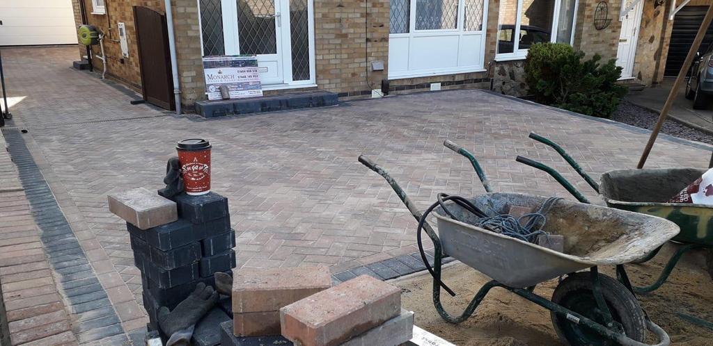 Finished block paving and a new front step, with a Monarch site board by the door