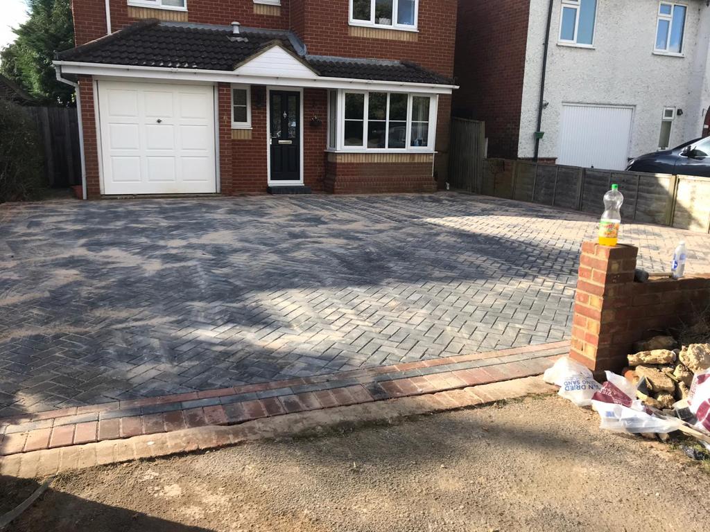 Finished charcoal block-paved driveway in front of a white garage door
